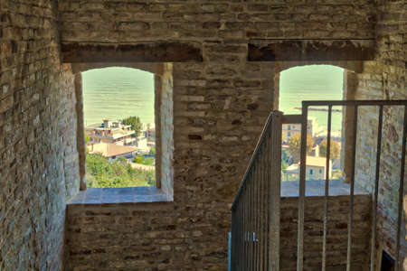Panorama on ancient Italian maritime town through brick windowsの写真素材