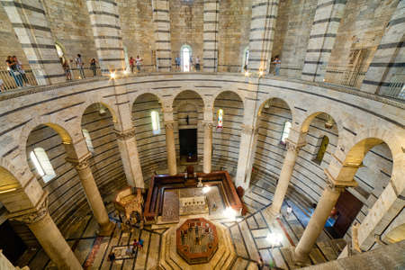PISA, ITALY - SEPTEMBER 1, 2017: Tourists visit the interiors of the largest Baptistery in Italy