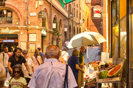 BOLOGNA, ITALY - AUGUST 27, 2016:  tourists and locals go shopping in medieval market. The trade...