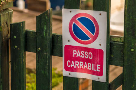 Wooden fence with no parking sign and  Italian sentence meaning drivewayの写真素材