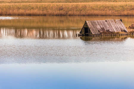 old shed on sea lagoon  in winterの写真素材