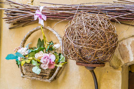 Wicker lamp near floral composition of plastic flowersの写真素材