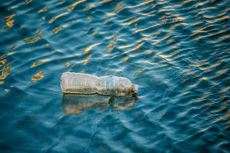 Floating plastic bottle in waving water