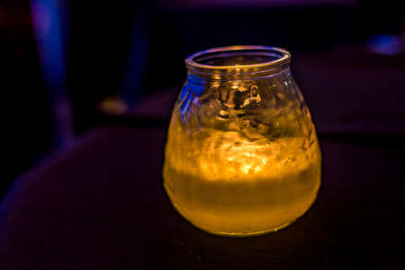 wax candle burning in glass jar