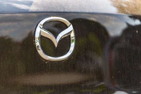 RAVENNA, ITALY - JUNE 30, 2018: Dirt and dust cover the MAZDA logo on a car bodyのeditorial素材