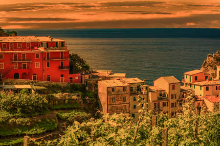 sunset on colorful houses overlooking deep blue sea in Italy