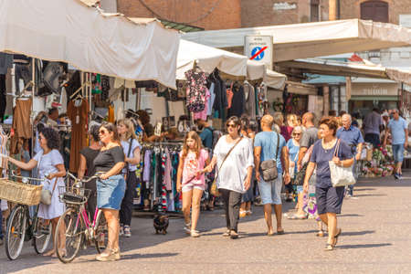FERRARA, ITALY - AUGUST 24, 2018: Tourists and locals have fun shopping in the weekly market