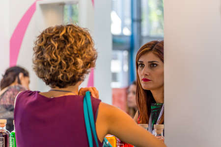 BOLOGNA (ITALY), SEPTEMBER 10, 2018:  Visitors are visiting a stand and asking exhibitor about the...
