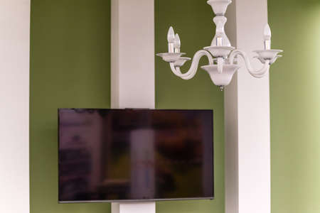 Elegant Liberty style chandelier in front of a LCD TV