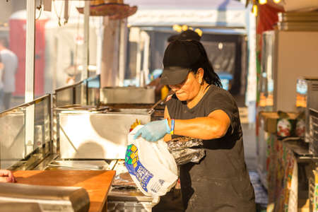 CERVIA (RA), ITALY - SEPTEMBER 16, 2018: woman preparing Mexican food for sale at European Market,...