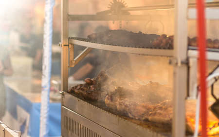 Argentinian Meat is smoking while baking on the grill in a street marketの写真素材