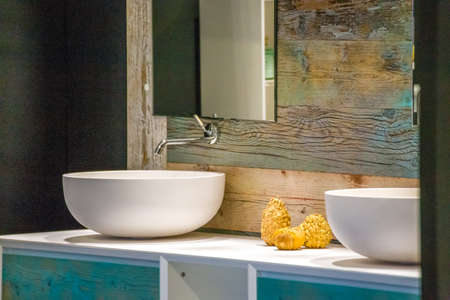 chrome faucet and two sinks on wooden vanity top