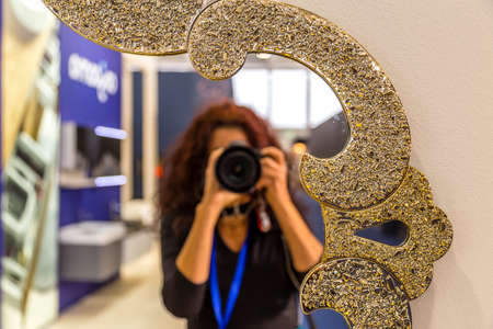 female photographer while shooting a vintage mirror on wallのeditorial素材