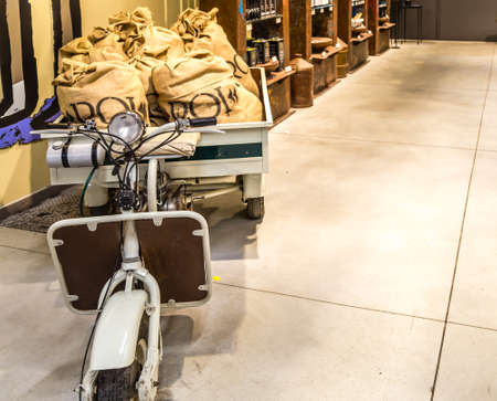 BOLOGNA, ITALY - OCTOBER 2, 2018: lights are enlightening old scooter with jute sacks at FICO EATALY WORLD, the largest agri-food park in the worldのeditorial素材