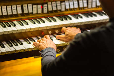 male hands playing organ keyboard in church