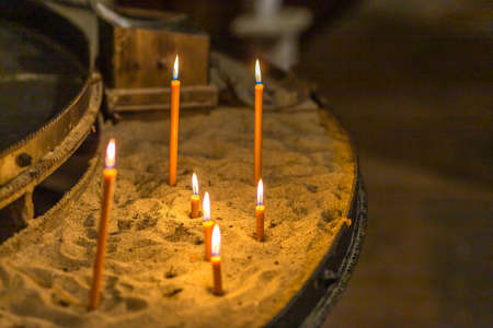 burning votive candles in the sandの写真素材