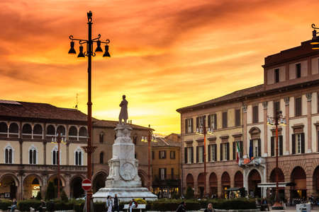 winter sunset on historical square with monument in Italian town