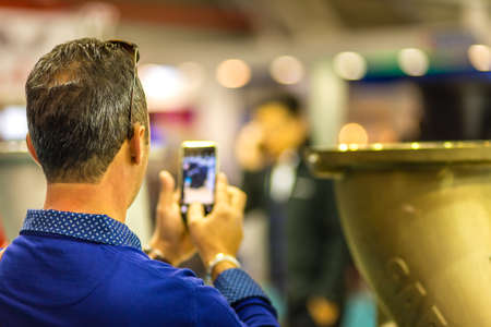 BOLOGNA, ITALY â NOVEMBER 10, 2018: people visiting the fair and shooting photos with mobile phone at EIMA 2018,  International Agricultural and Gardening Machinery Exhibitionのeditorial素材