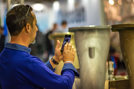 BOLOGNA, ITALY â€“ NOVEMBER 10, 2018: people visiting the fair and shooting photos with mobile...