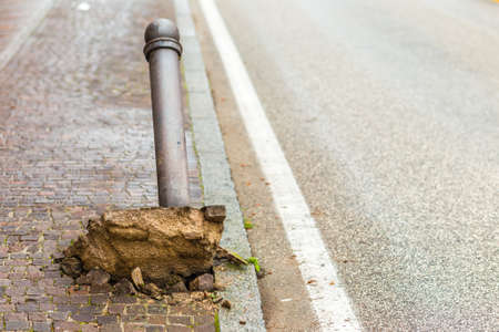 Uprooted and ripped through bollard in city street,の写真素材