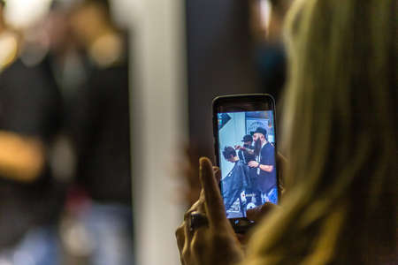 BOLOGNA, ITALY - NOVEMBER 25, 2018:  Hairstylist performs hairstyle in a stand.のeditorial素材