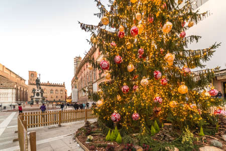 BOLOGNA, ITALY - DECEMBER 10, 2018: Christmas lights are enlightening people walking near fountain of Neptune, main attraction in historical center of Bolognaのeditorial素材