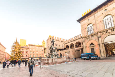BOLOGNA, ITALY - DECEMBER 10, 2018: Christmas lights are enlightening people walking near fountain of Neptune, main attraction in historical center of Bolognaのeditorial素材