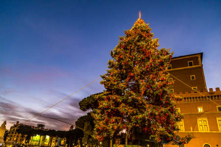 ROME, ITALY - JANUARY 1, 2019: tourists walking near Altar of the Fatherland while cars are passing and lights are shining on Christmas tree in Piazza Veneziaのeditorial素材