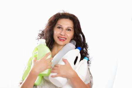 woman with long hair smiling and  holding plastic bottles for recycling. Caucasian but with Middle...