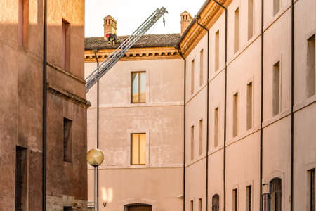 RAVENNA, ITALY - JANUARY 15, 2019: A brave firefighter checks the damage caused by the earthquake and removes the dangerous roof tiles from the State Historical Archives buildingのeditorial素材