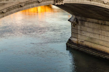 waters of river flowing under ancient bridgeの写真素材