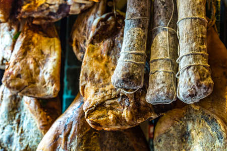 hanged hams for sale in Italian butcher Shop