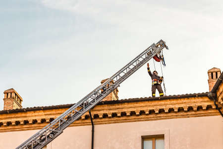 RAVENNA, ITALY - JANUARY 15, 2019: A brave firefighter checks the damage caused by the earthquake and removes the dangerous roof tiles from the State Historical Archives buildingのeditorial素材