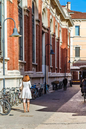 RAVENNA, ITALY - JANUARY 15, 2019: back of classy woman walking in street of the historical centerのeditorial素材