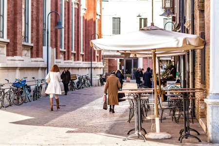 RAVENNA, ITALY - JANUARY 15, 2019: back of classy woman walking in street of the historical center