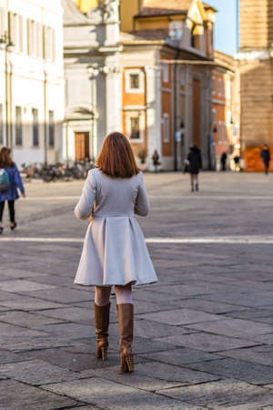 RAVENNA, ITALY - JANUARY 15, 2019: back of classy woman walking in street of the historical center