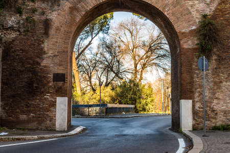 asphalted road through ancient brick archの写真素材