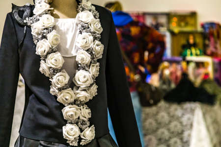 CESENA, ITALY - NOVEMBER 18, 2018: lights are enlightening old dress with white roses for sale in Antiques Fairのeditorial素材