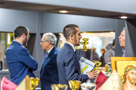 BOLOGNA, ITALY - FEBRUARY 18, 2019: Booth presenter talking with visitor at stand of ART DEMETZ in DEVOTIO Religious products and service exhibitionのeditorial素材