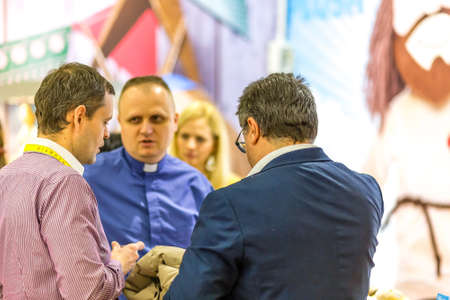 BOLOGNA, ITALY - FEBRUARY 18, 2019: Booth presenter talking with visitors at stand in DEVOTIO...