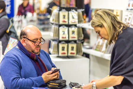 BOLOGNA, ITALY - FEBRUARY 18, 2019: Booth presenter talking with visitor at stand of ATS ITALIA...