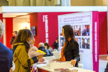 BOLOGNA, ITALY - FEBRUARY 18, 2019: hostess welcoming visitors in DEVOTIO Religious products and service exhibitionのeditorial素材