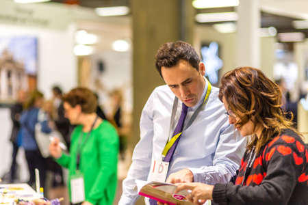 BOLOGNA, ITALY - FEBRUARY 18, 2019: booth presenter talking with visitor at stand of LA RONDE DES COULEURS in DEVOTIO Religious products and service exhibitionのeditorial素材