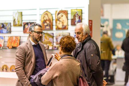 BOLOGNA, ITALY - FEBRUARY 18, 2019: booth presenter talking with visitor at stand of FERRARI E ARRIGHETTI in DEVOTIO Religious products and service exhibitionのeditorial素材