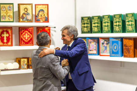BOLOGNA, ITALY - FEBRUARY 18, 2019: booth presenter talking with visitor at stand of SICOM in...