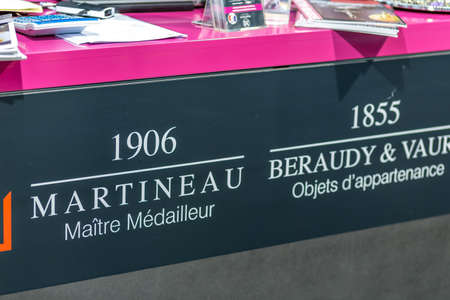 BOLOGNA, ITALY - FEBRUARY 18, 2019: lights are enlightening MARTINEAU logo on signboard on stand in...