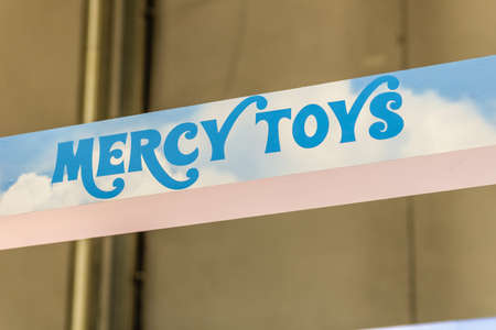 BOLOGNA, ITALY - FEBRUARY 18, 2019: lights are enlightening MERCY TOYS logo on signboard on stand in...