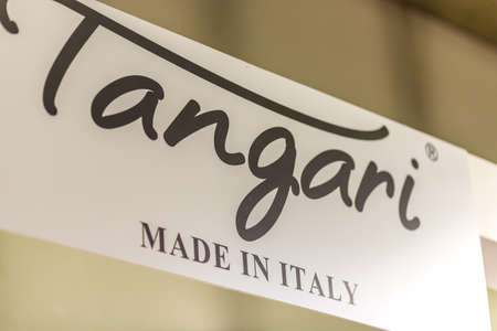 BOLOGNA, ITALY - FEBRUARY 18, 2019: lights are enlightening TANGARI logo on signboard on stand in...