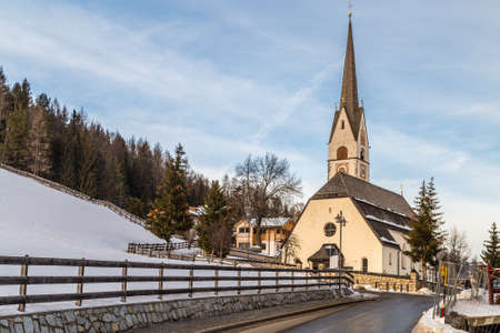 Catholic church in Alpine snowy panoramaの写真素材