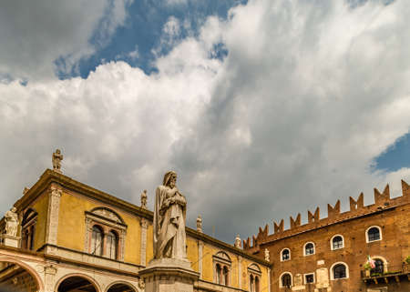 VERONA (VR), ITALY - MAY 10, 2019: sunlight is enlightening statue of Dante Alighieri holding his chin in Piazza dei Signori in Veronaの写真素材